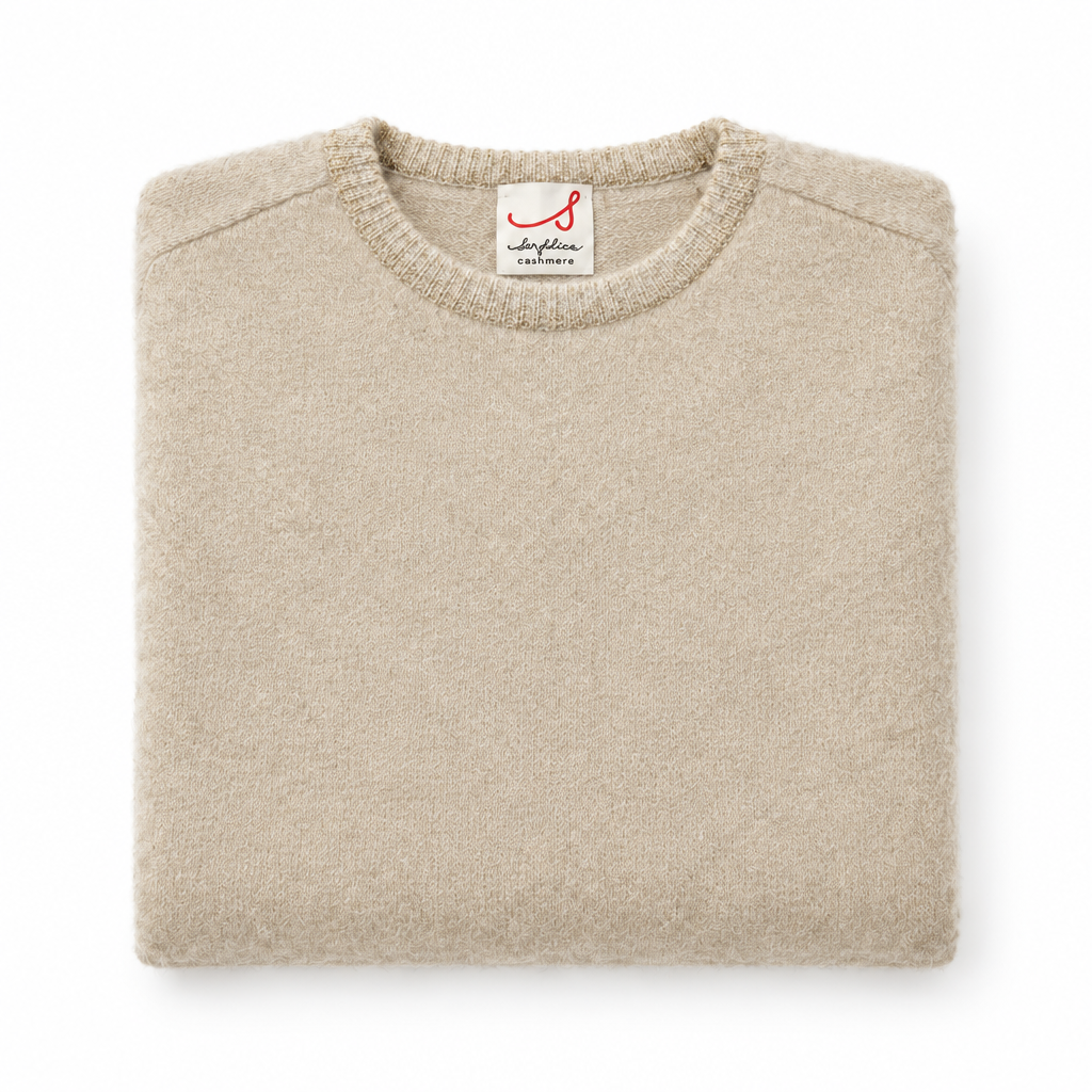Golf beige piegato con collo lamé oro su sfondo bianco